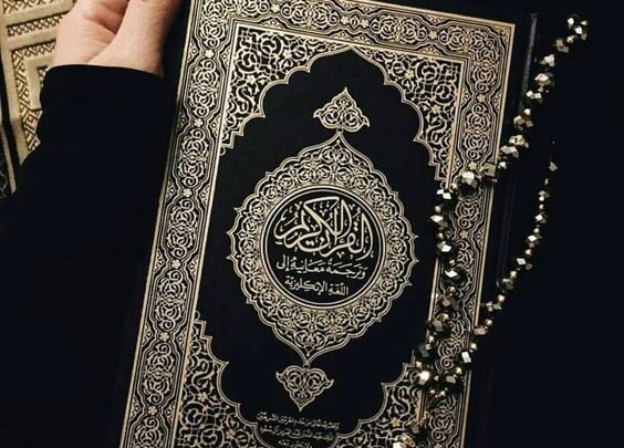 فتاة تمسك بالمصحف الكريم.